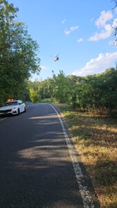 Straße mit Auto und Hubschrauber in der Luft