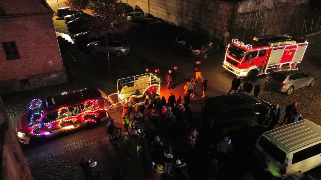 Feuerwehrauto mit festlichen Lichtern bei Nacht