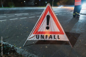 Unfallwarnschild auf nächtlicher Straße platziert.