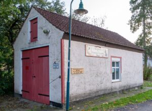 Historisches Gebäude mit roter Tür und Schildern.