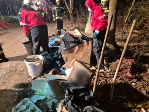 Feuerwehrleute entsorgen illegalen Müll im Wald.