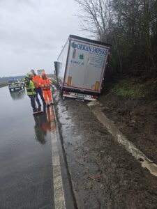 LKW im Straßengraben mit Polizei im Einsatz.